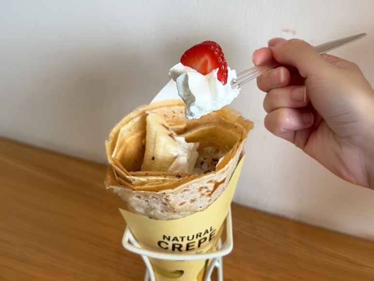 ナチュラルクレープのイチゴバナナチョコホイップを食べるところ