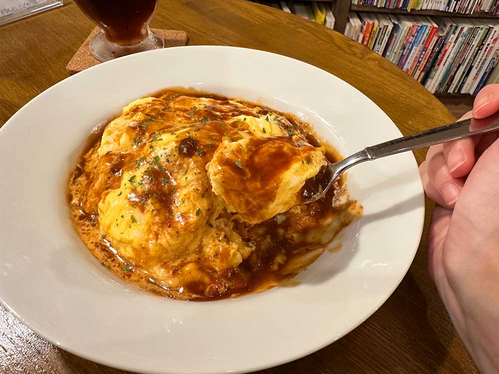 地理系ブックカフェ-空想地図のオムライスをスプーですくうところ
